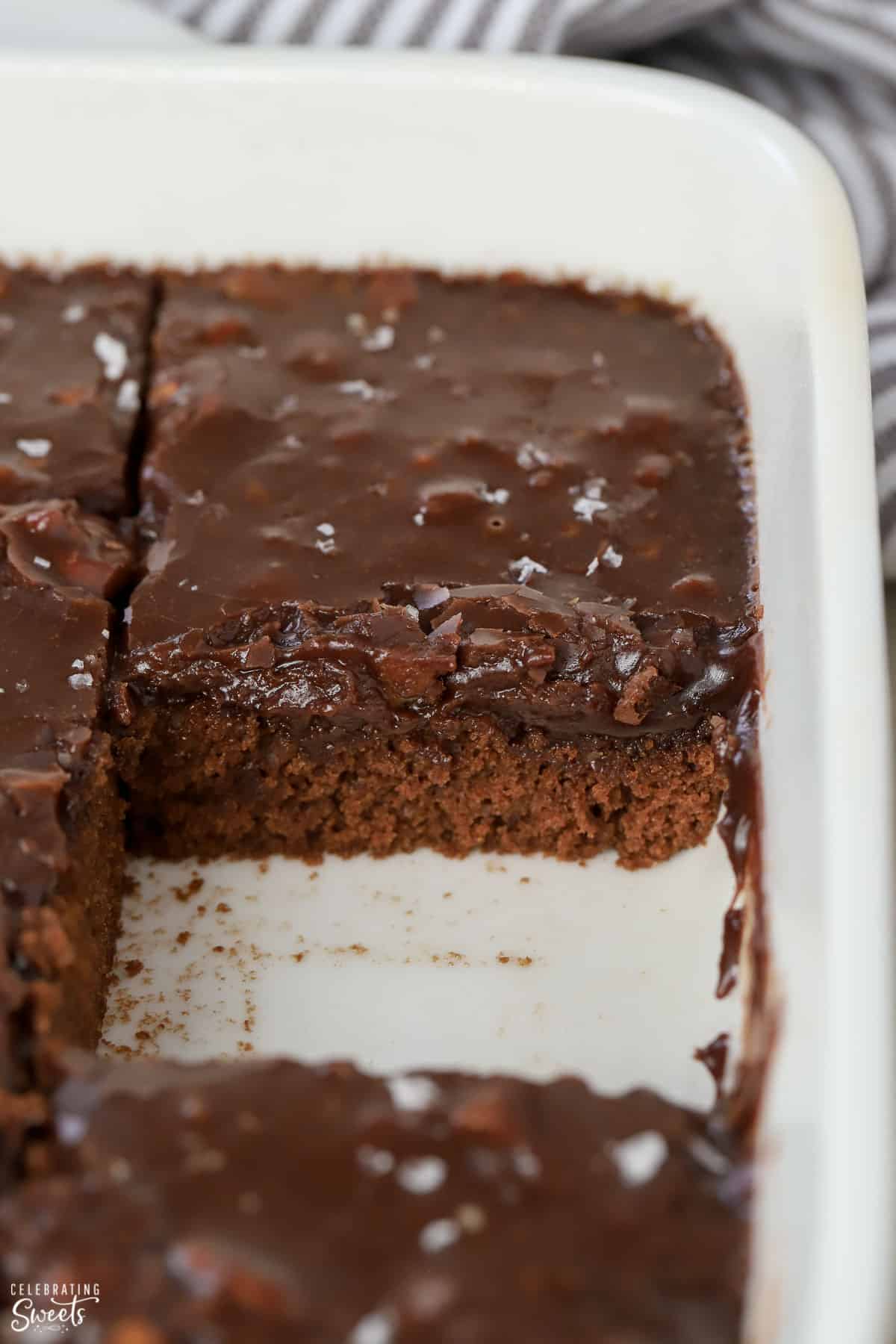 Chocolate cake with chocolate icing in a white baking dish.