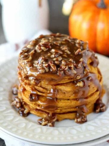 Stack of pumpkin pancakes topped with pecan syrup.