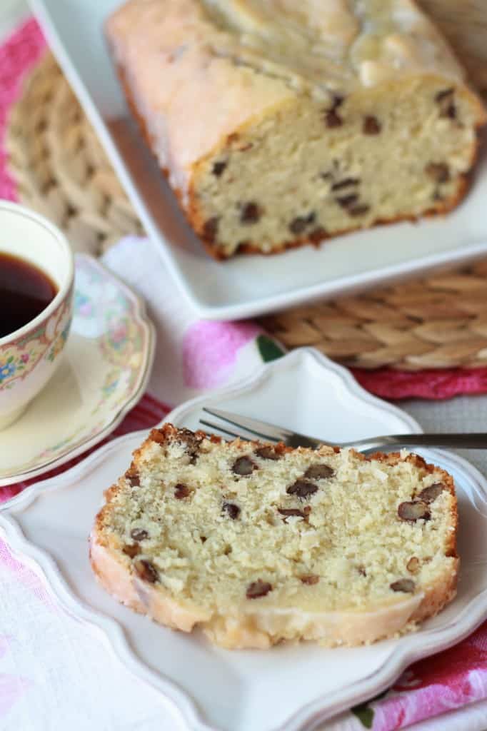 Slice of cake on a white plate with a cup of coffee.