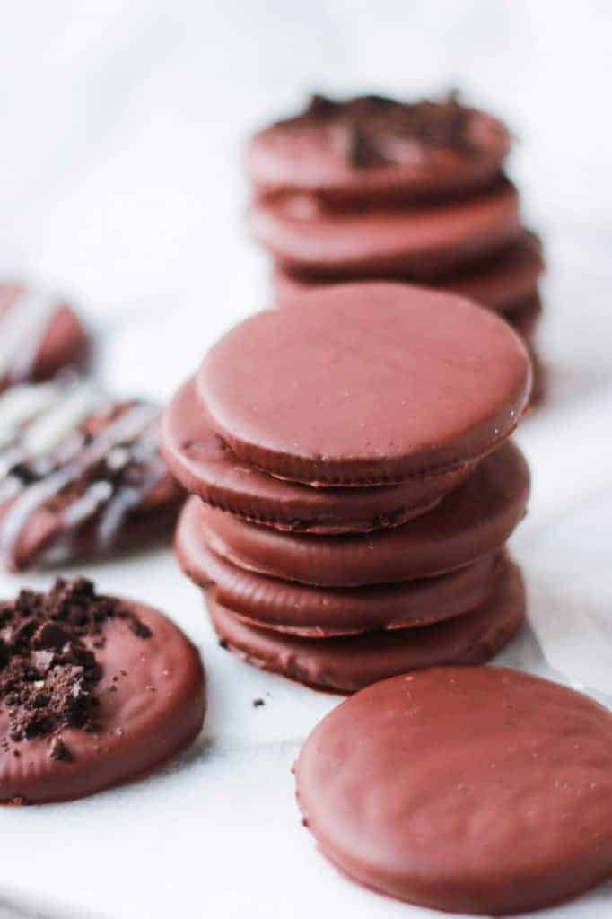 Stack of thin chocolate cookies on a white board. 