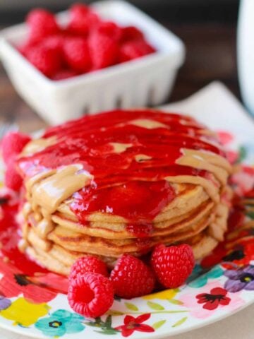 Stack of pancakes topped with melted peanut butter and jelly.