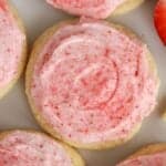 Closeup of sugar cookie topped with pink frosting.