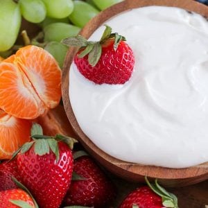 Bowl of dip with fruit around it.
