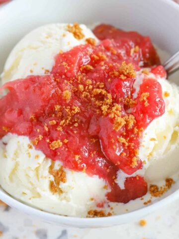 Rhubarb Sauce over vanilla ice cream in a white bowl.