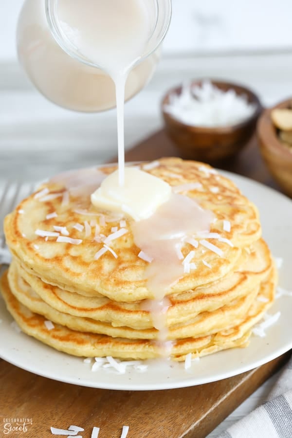 Coconut syrup poured over a stack of coconut pancakes.
