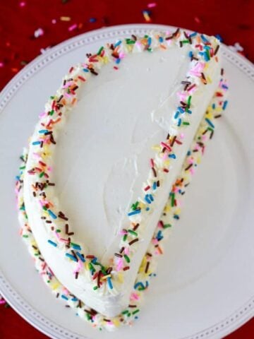 Half birthday cake with white frosting and colored sprinkles.