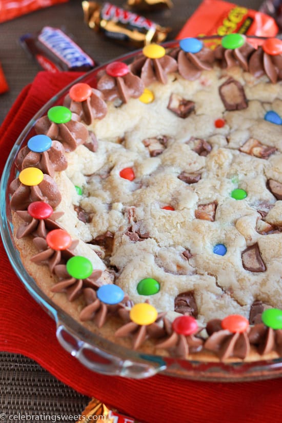 Cookie cake filled with candy bars and topped with chocolate frosting.