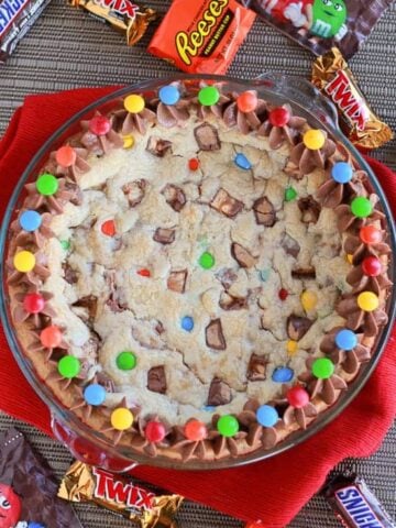 Cookie cake topped with M&M's candies and chocolate frosting.