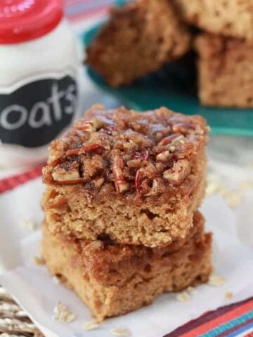 Two slices of cake topped with pecans.