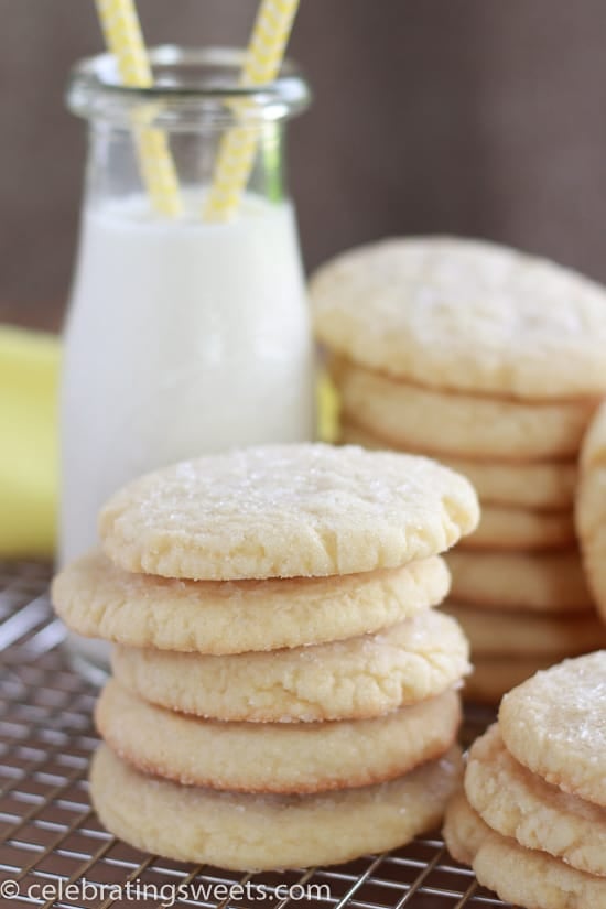 Stack of sugar cookies with milk in the background.