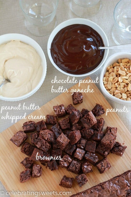 Board with brownies and bowls of whipped cream and fudge sauce. 