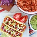Chicken tacos on a white plate.