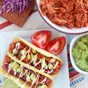 Chicken tacos on a white plate.