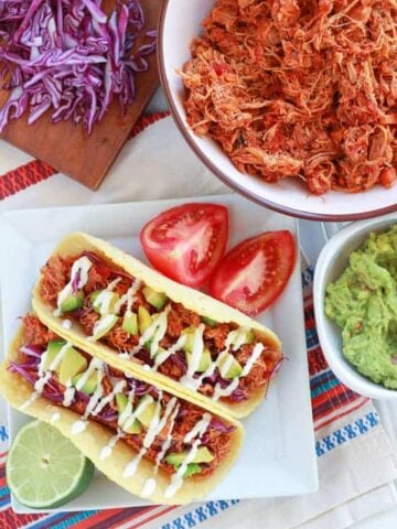Chicken tacos on a white plate.