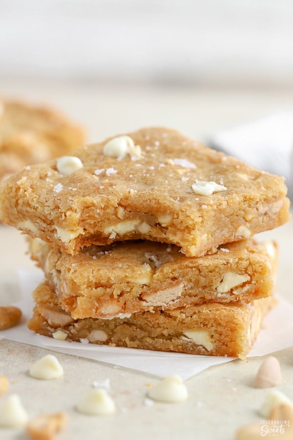 Stack of three blondie bars on parchment paper. 