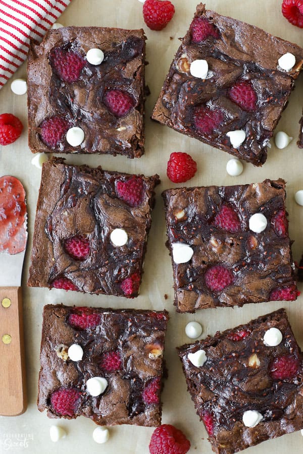 Raspberry brownies on a piece of brown parchment paper.