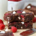 A close up of two brownies on parchment paper.