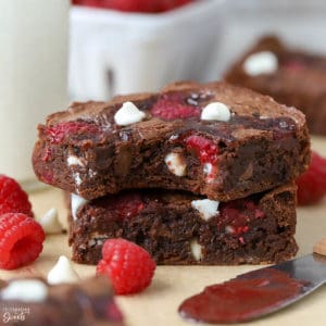A close up of two brownies on parchment paper.
