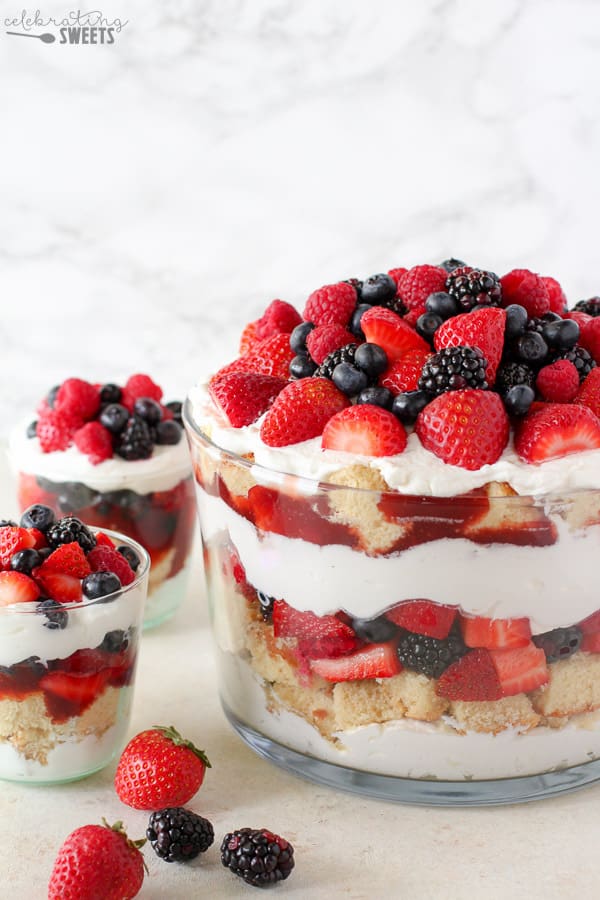 Trifle dish filled with cake, berries, and whipped cream.