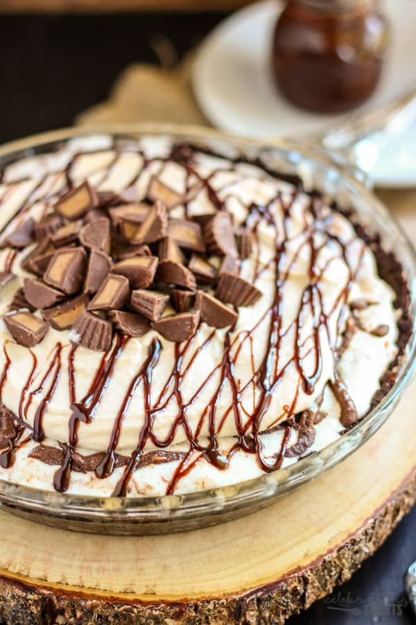 Peanut butter ice cream pie topped with fudge sauce and chopped peanut butter cups.