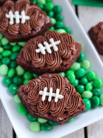 Football shaped brownies on top of green M&M's.