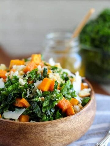 Kale and sweet potato salad in a wooden bowl.