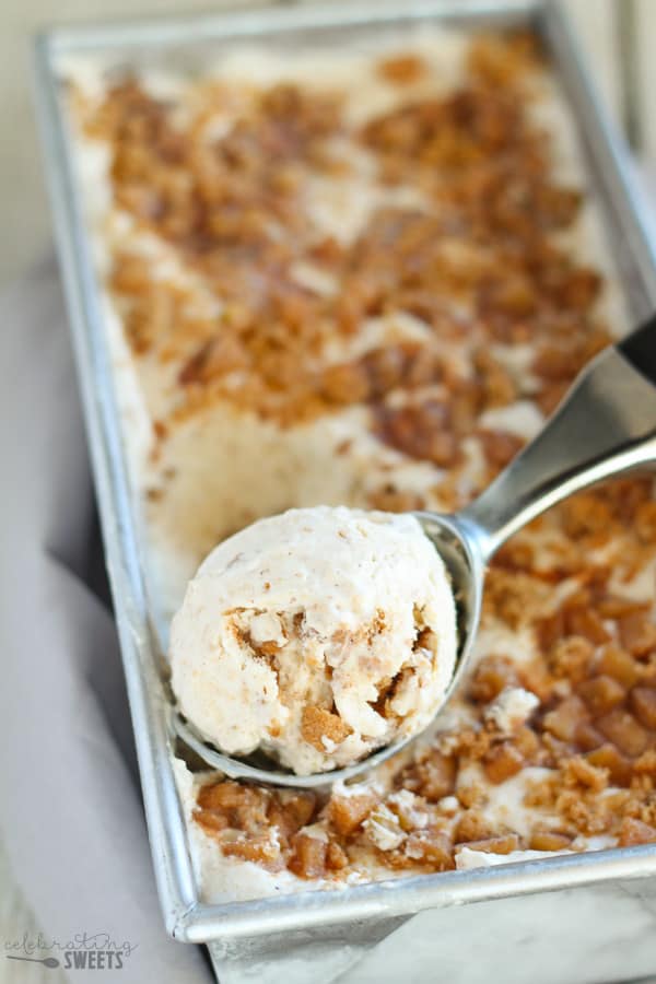 Apple pie ice cream in a metal loaf pan with an ice cream scoop.