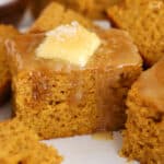 Slice of pumpkin cornbread topped with butter and honey.