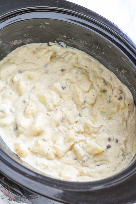 Creamy potatoes in a black slow cooker.