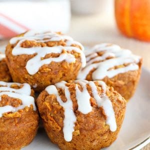 Healthy Pumpkin Muffins ona white plate with a pumpkin in the background.