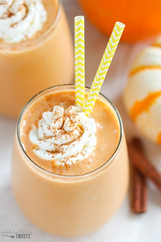Pumpkin smoothie in a glass topped with whipped cream and cinnamon.