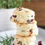 Stack of three cranberry muffins on a white plate.