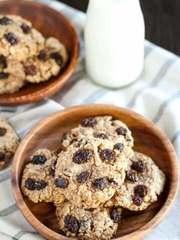 Oatmeal raisin cookies on a wooden plate.