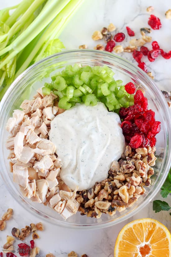 Ingredients for chicken salad in a glass bowl.