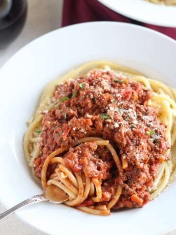 Bowl of pasta topped with meat sauce.