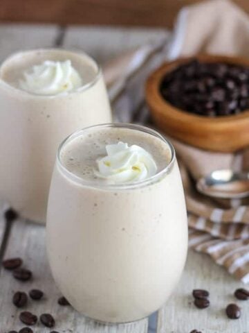 Coffee smoothie in a glass topped with whipped cream.