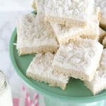 Stack of sugar cookie bars topped with coconut.