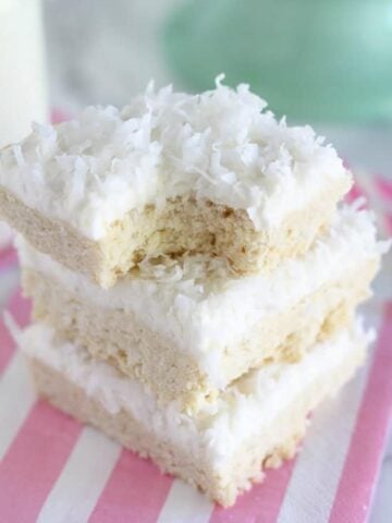 Stack of sugar cookie bars topped with coconut.