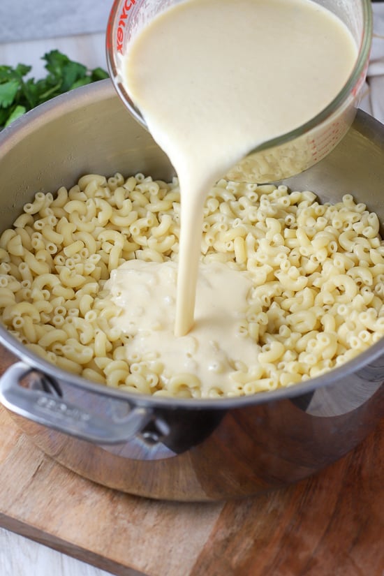 Pot of macaroni pasta with white cheese sauce poured in.