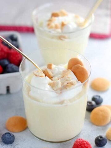 Vanilla pudding in a glass with vanilla wafer cookies.
