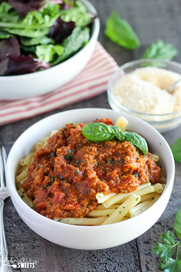 Meat sauce on pasta with herbs.