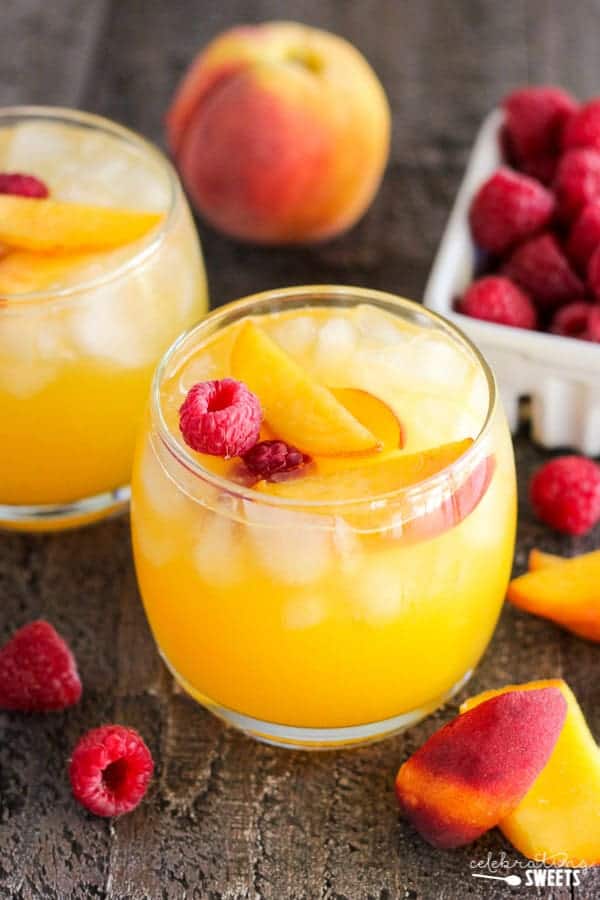 Peach margarita garnished with peaches and raspberries.