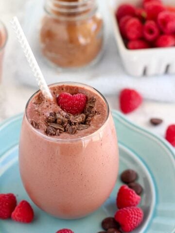Chocolate smoothie topped with raspberries.
