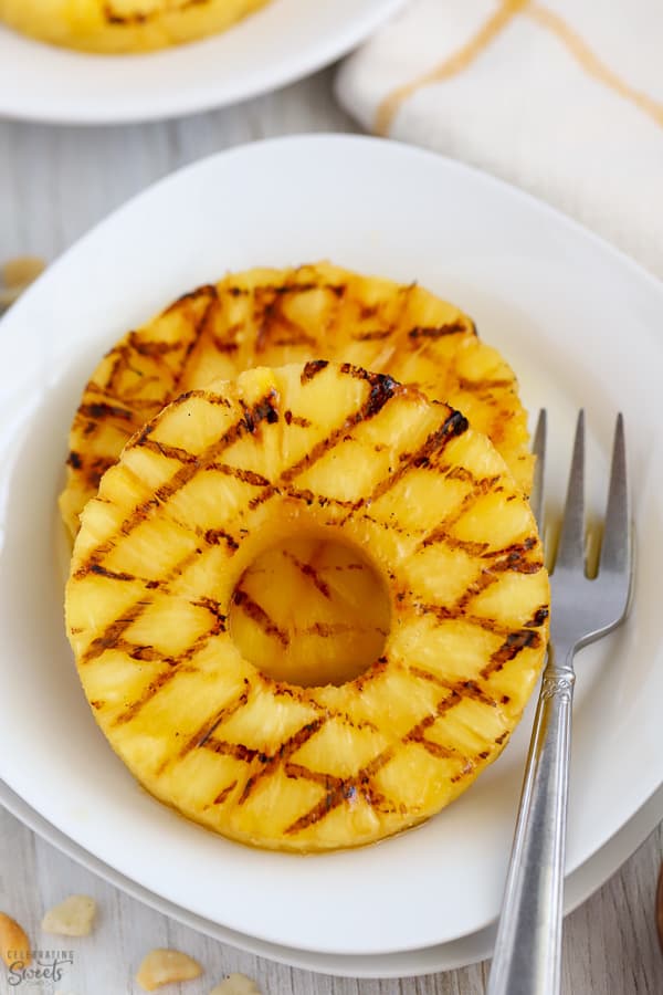 Grilled pineapple slices on a white plate.