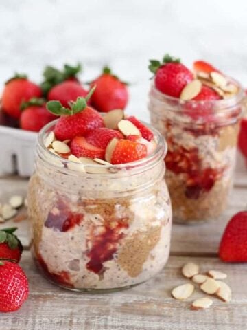 Overnight oats in a jar with strawberries and almond butter.