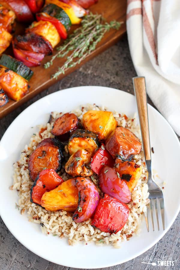 Plate of rice with grilled vegetables and sausage.