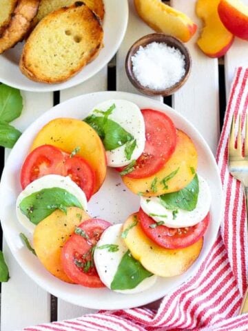 Sliced peaches, tomato, and mozzarella topped with basil.