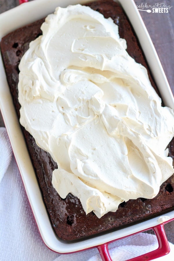 Whipped cream on top of a chocolate cake.