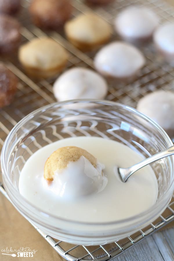 Bowl of icing with a donut hole in it.
