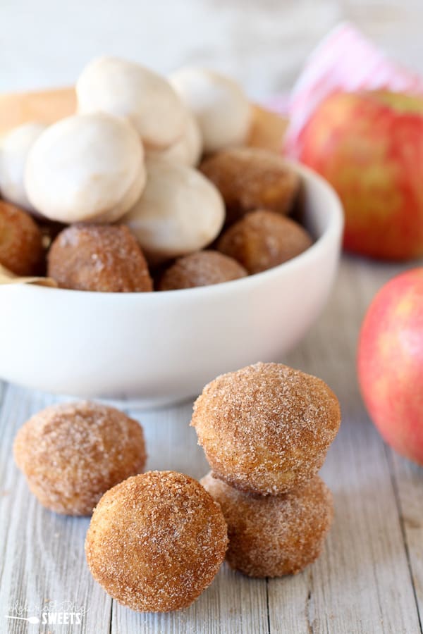 Donut holes with cinnamon sugar and icing in a bowl.